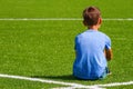 Sad alone boy sitting in soccer field stadium outdoors Royalty Free Stock Photo