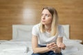 Sad one woman complains about pregnancy test sitting on sofa in living room at home, frustrated with results