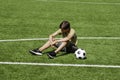 Sad alone teenage boy sitting in empty school sport stadium outdoors. Emotions, defeat, lost game, difficulties