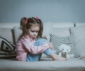 Sad or angry little girl, victim, holding toy dog. Royalty Free Stock Photo