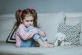 Sad or angry little girl, victim, holding toy dog. Royalty Free Stock Photo