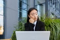 Anxious Asian student, received disappointing news about entering university and college, sitting on a bench with a laptop