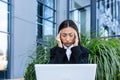 Sad and anxious Asian student, received disappointing news about entering university and college, sitting on a bench with a laptop