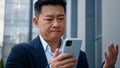 Sad Asian middle-aged adult man mad unhappy businessman feeling annoyed with using broken smart phone low battery Royalty Free Stock Photo