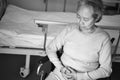 Sad asian old woman sitting in wheelchair next to hospital bed Royalty Free Stock Photo