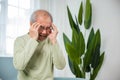 Sad Asian senior man sitting on sofa feeling hurt and lonely Royalty Free Stock Photo