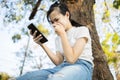 Sad asian student victim of cyber bullying online sitting alone outdoor at school,teenage girl receiving text message at mobile