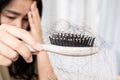 Asian woman have a problem with hair loss after brushing  holding a comb with hair fall Royalty Free Stock Photo