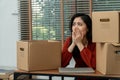 Sad Asian woman Packing belongings in a cardboard box and crying on the desk in the office After being layoff and unemployed.