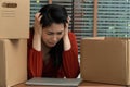 Sad Asian woman Packing belongings in a cardboard box and crying on the desk in the office After being layoff and unemployed.