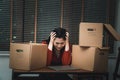 Sad Asian woman Packing belongings in a cardboard box and crying on the desk in the office After being layoff and unemployed.