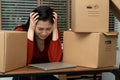 Sad Asian woman Packing belongings in a cardboard box and crying on the desk in the office After being layoff and unemployed.