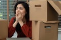 Sad Asian woman Packing belongings in a cardboard box and crying on the desk in the office After being layoff and unemployed.