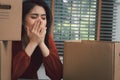 Sad Asian woman Packing belongings in a cardboard box and crying on the desk in the office After being layoff and unemployed.