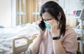 Sad asian woman using cell phone to tell relative bad news,stressed worried about worsening health after surgery,grieving crying