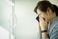 Sad asian woman using phone and grieving,crying alone in hospital,female people waiting for the doctor in front of the ICU room, Royalty Free Stock Photo