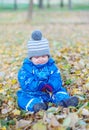 Sad baby boy sitting on yellow leaves in autumn Royalty Free Stock Photo