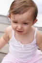 Sad baby, face and sitting outside of curious toddler, little girl or disappointed on outdoor porch. Closeup of young