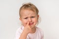Sad baby girl is picking her nose with finger inside Royalty Free Stock Photo
