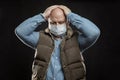 Sad bald adult man in a medical mask stands holding his head with his hands. Precautions quarantined for the period of the Royalty Free Stock Photo