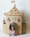 Sad beautiful little girl in princess dress playing with her toy castle. Royalty Free Stock Photo
