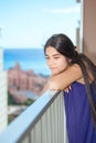 Sad biracial teen girl on outdoor highrise patio, ocean backgro Royalty Free Stock Photo