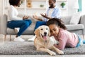 Sad black girl embracing dog, parents fighting in the background Royalty Free Stock Photo