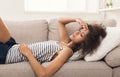 Sad black girl feeling pain lying on sofa Royalty Free Stock Photo