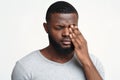 Sad black guy touching his eye, suffering from conjuctivitis