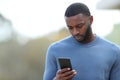 Sad black man reading chat on phone Royalty Free Stock Photo