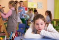 Sad bored schoolgirl in classroom at break Royalty Free Stock Photo