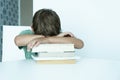 Sad boy with book does school homework. Back to school. Unhappy schoolboy with textbooks. Distance learnin Royalty Free Stock Photo