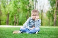 Sad boy with book on green grass Royalty Free Stock Photo