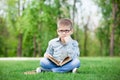 Sad boy with book on green grass Royalty Free Stock Photo