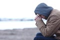 Sad boy complaining in winter on the beach Royalty Free Stock Photo