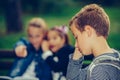 Sad boy feeling left out, teased and bullied by his classmates