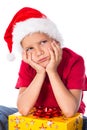 Sad boy with gift box in christmas hat Royalty Free Stock Photo