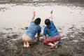 Sad boy and girl praying for the rain on lake