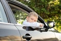 The sad boy got out of the car window and looks away. Open car window Royalty Free Stock Photo