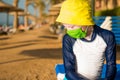 Sad boy in green mask on empty beach line Royalty Free Stock Photo