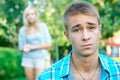 Sad boy with his girlfriend on the background Royalty Free Stock Photo