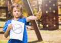 Sad boy holdingn anti bullying sign against playground