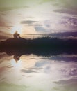 Sad boy silhouette worried on the meadow at sunset with water re Royalty Free Stock Photo