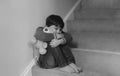 Sad boy sitting alone on staircase with teddy bear, Lonely kid looking dow with sad face not happy to go back to school, Depressed Royalty Free Stock Photo