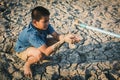 Sad boy want to drink some water on crack ground Royalty Free Stock Photo