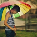 Sad boy withl rainbow umbrella Royalty Free Stock Photo