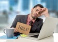 Sad businessman at office desk working on computer laptop asking for help depressed Royalty Free Stock Photo