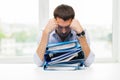 Sad businessman with stack of folders at office