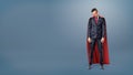 A sad businessman in a superhero red cape standing on dark blue background with his shoulders slumped. Royalty Free Stock Photo