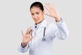 Sad caucasian millennial lady doctor, nurse in white coat make stop gesture